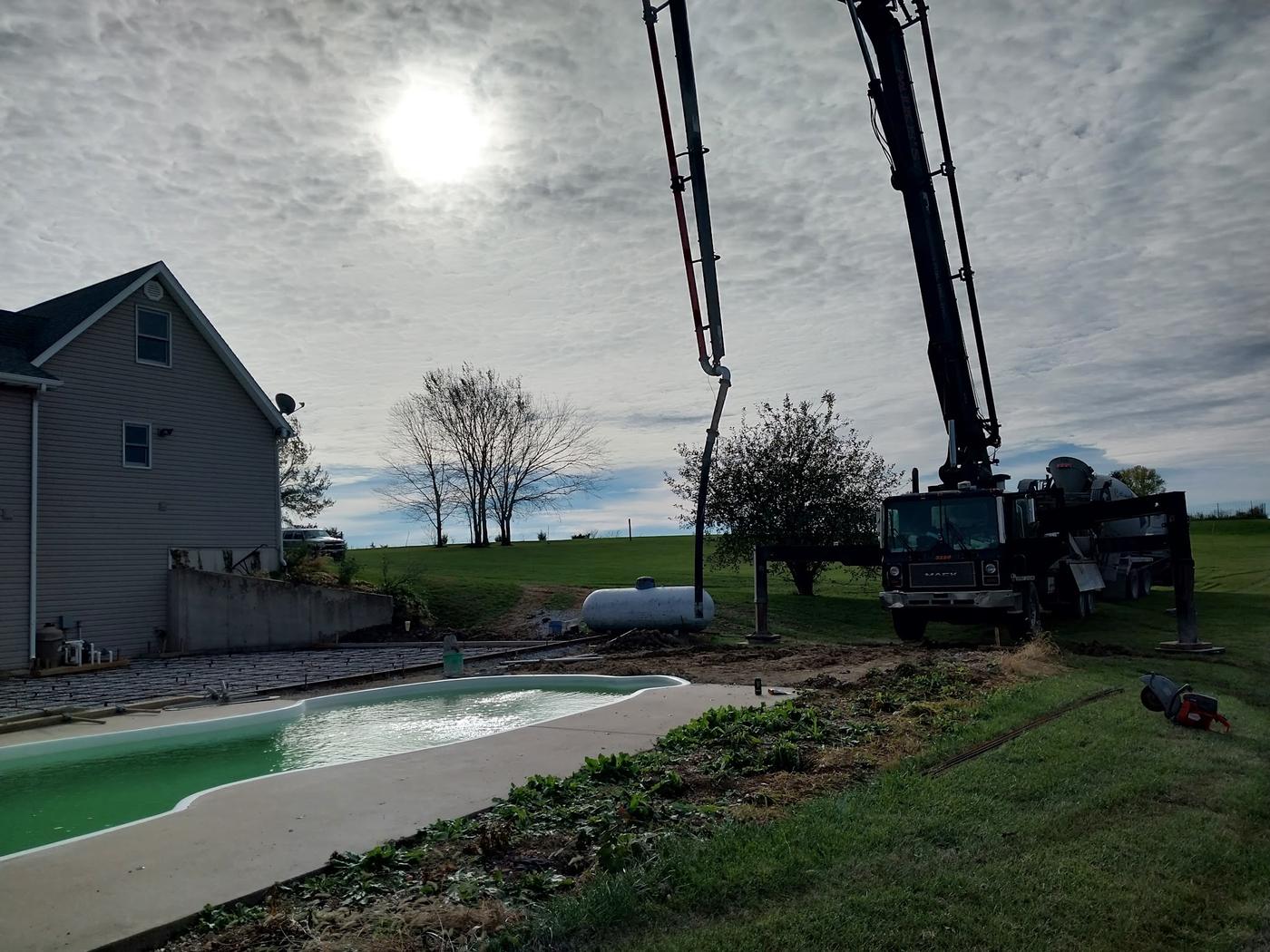 Poured around an in-ground pool with the boom pump reaching over the top of it.
